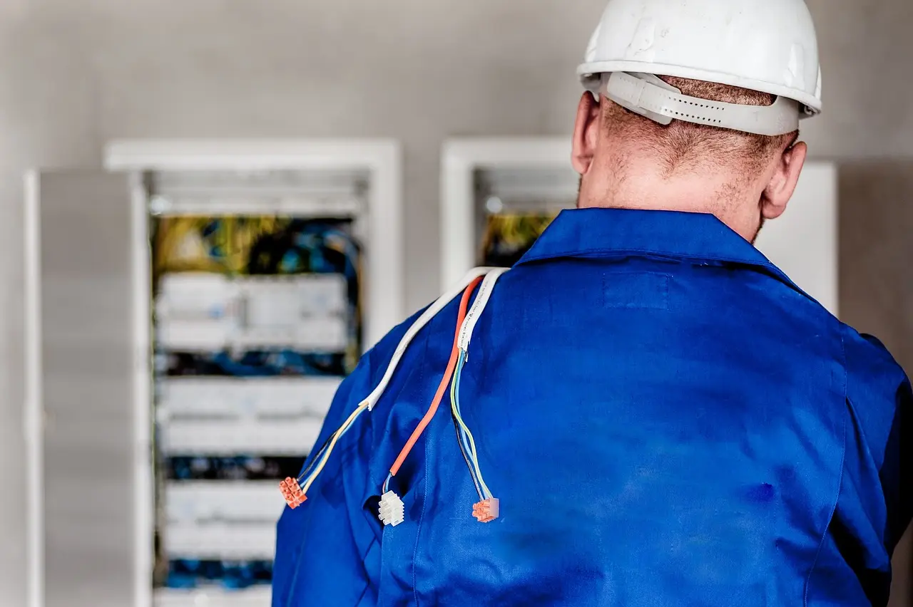 Foto de um eletricista mexendo em um quadro de energia.